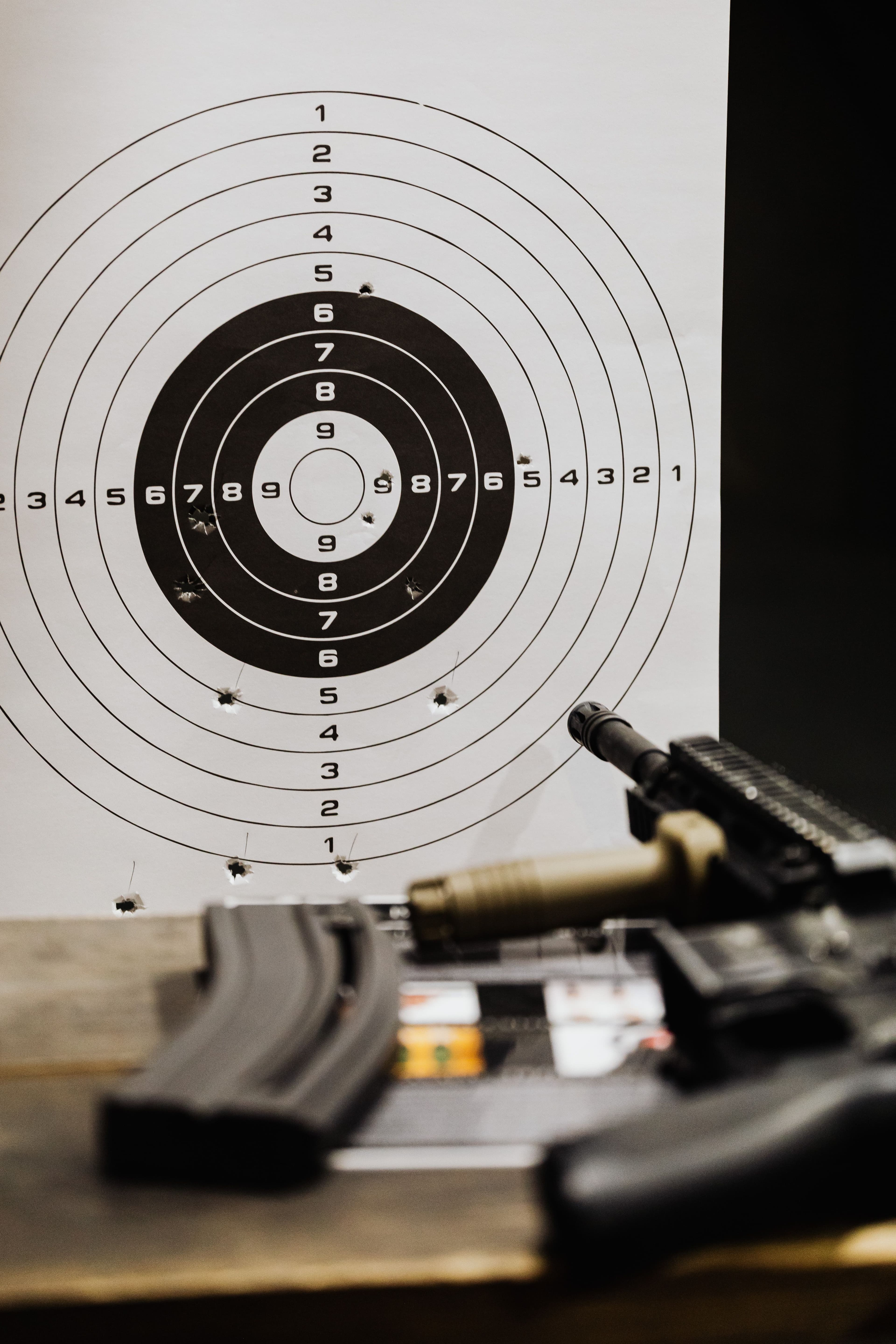 A paper shooting target with a grouped set of bullet holes.