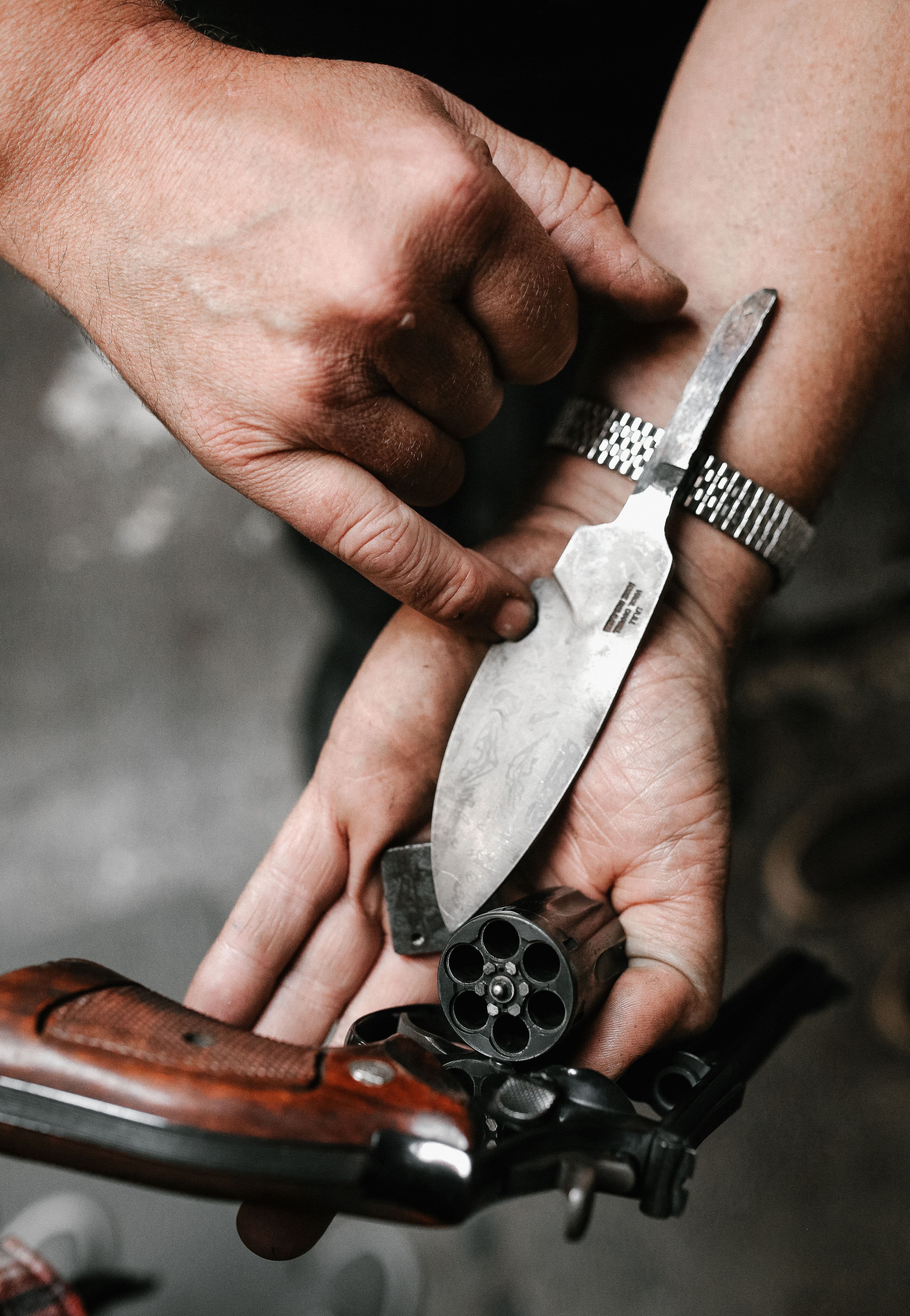 Hands inspecting an open revolver cylinder during a repair check.